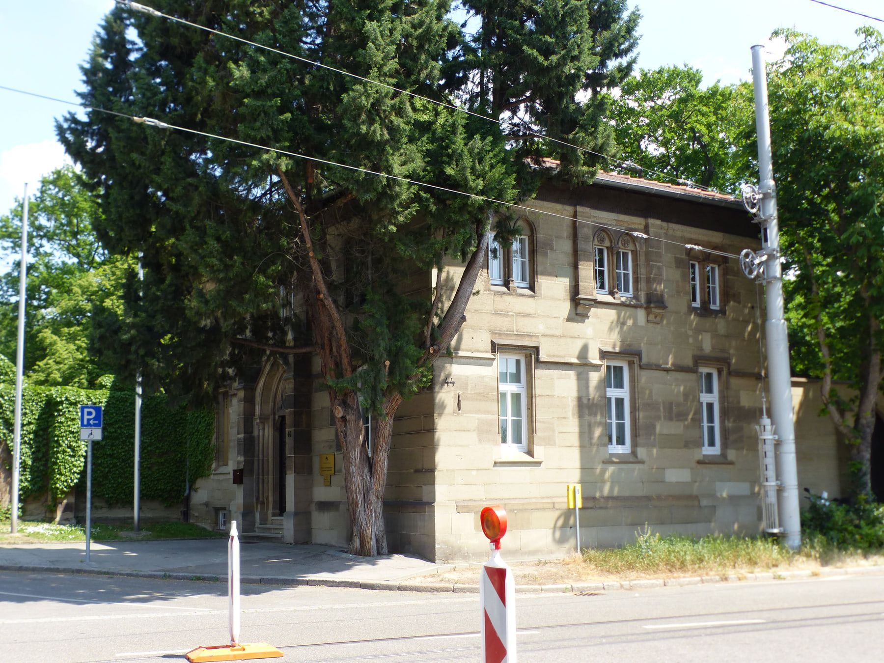 Historisches Verwaltungsgebäude an der Friedhofstraße hinter einer mächtigen Konifere auf Pragfriedhof Stuttgart